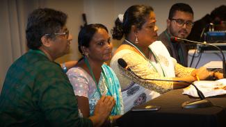 Three women seated about to speak at a conference