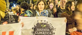 Protester holding a canvas that reads, "Justicia Climatica"