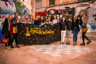 Crowd of people with a black banner that says Metzineres in yellow.