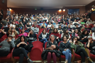 Photo de personnes assises sur des chaises rouges dans une salle de conférence